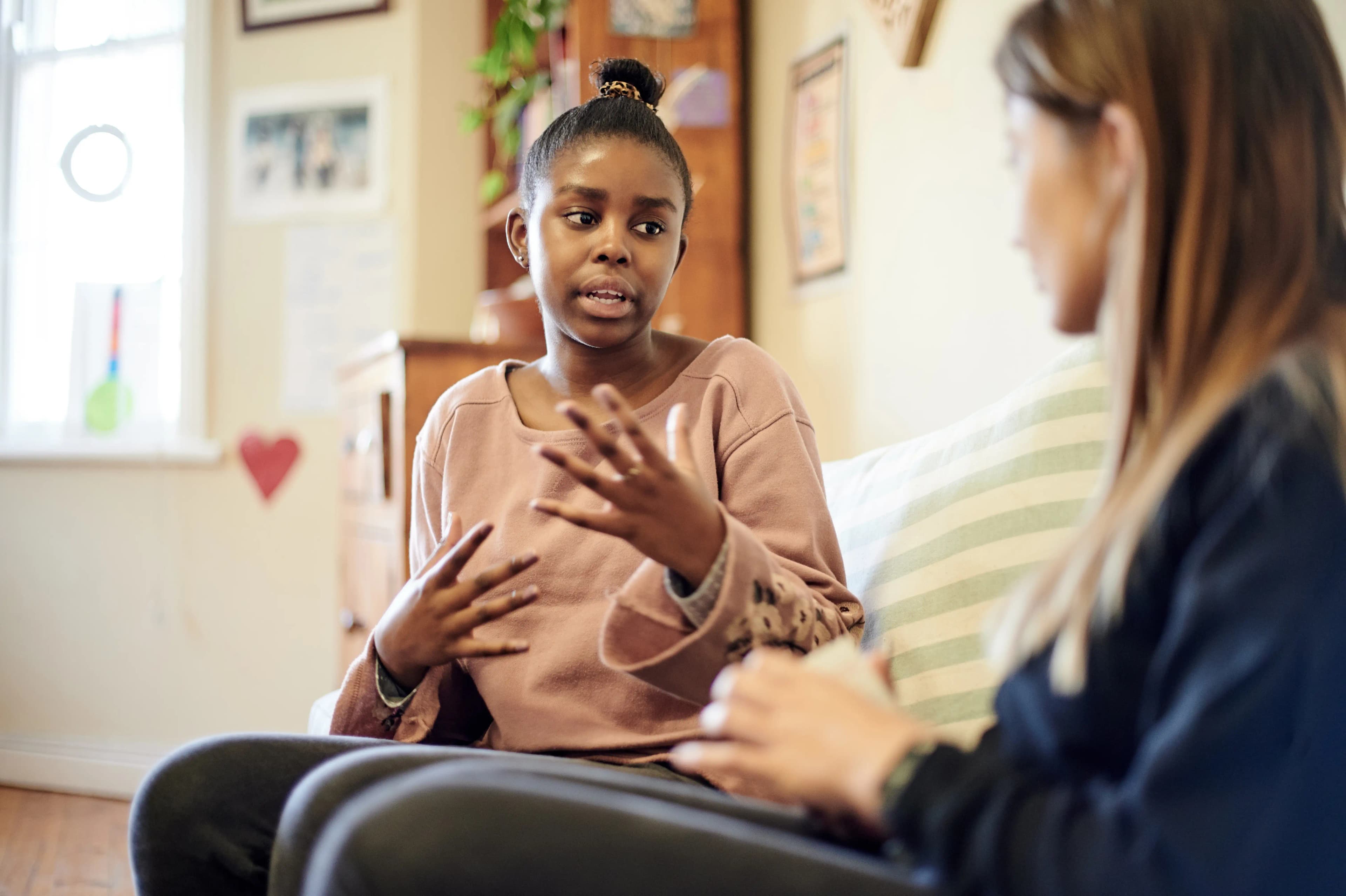 A young adult receiving calm, attentive support in a comfortable setting, reflecting a trauma-informed approach that prioritizes safety, understanding and compassion.